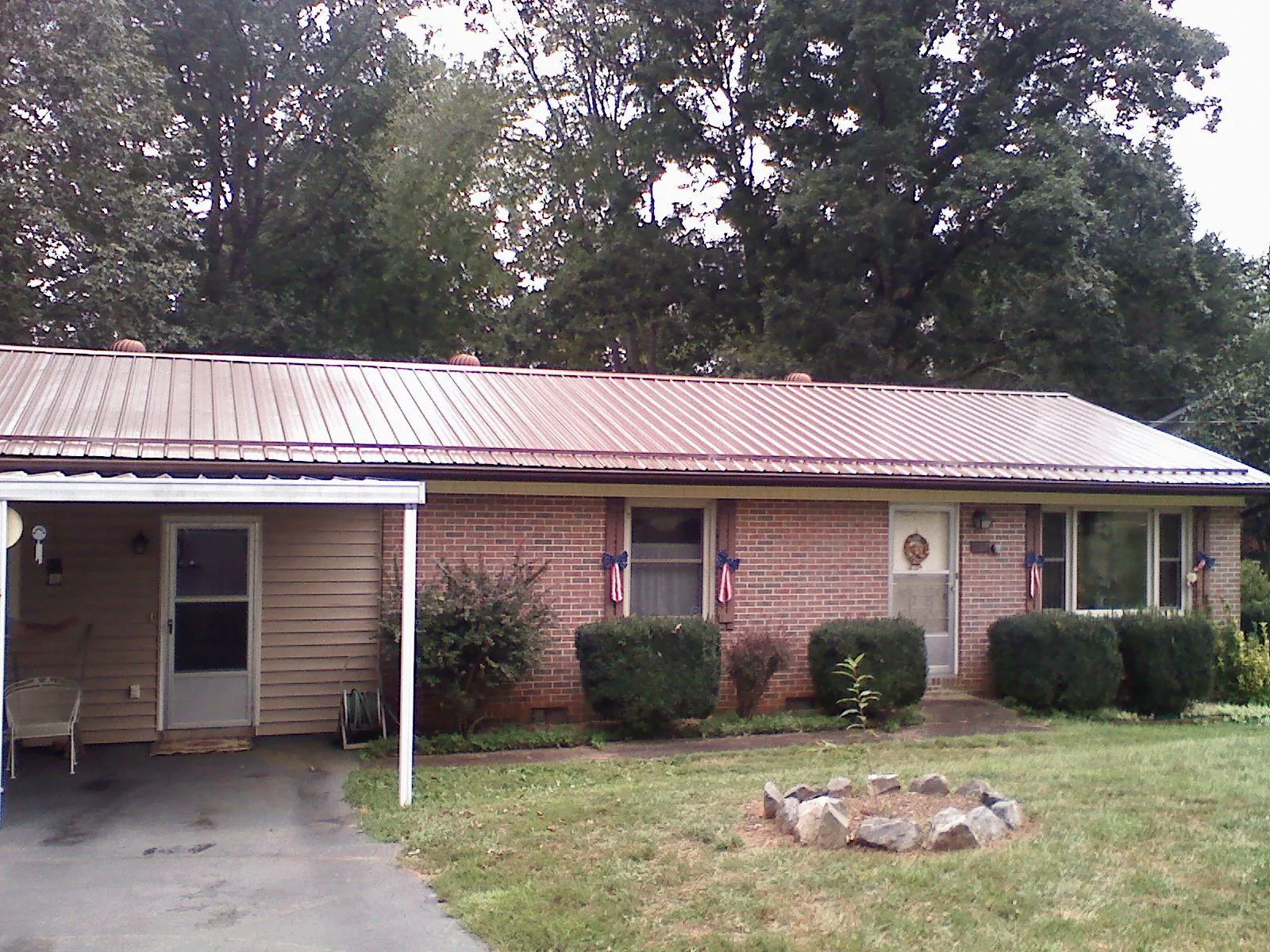 Bronze metal roof and carport on a brick ranch home — Roof Repair work by our crew in Olustee